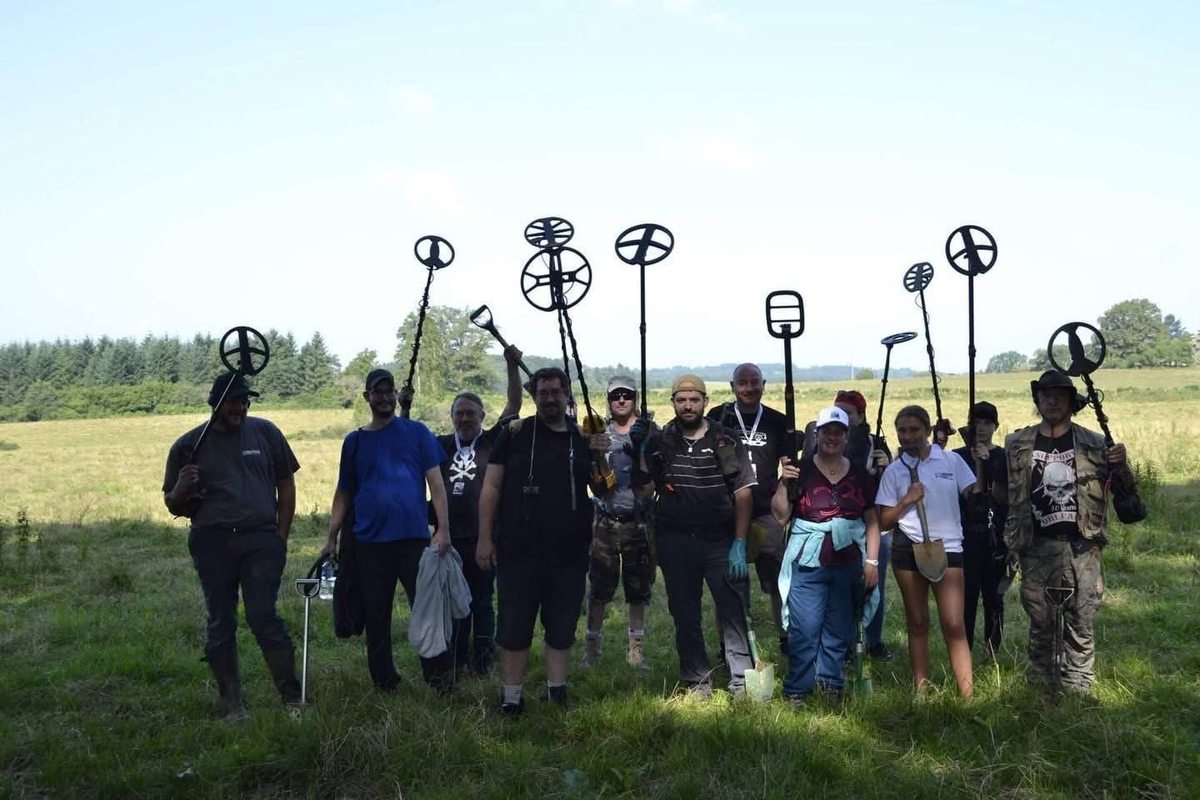 Groupe de stagiaires formés par l'OEPR, détecteurs levés dans un champ